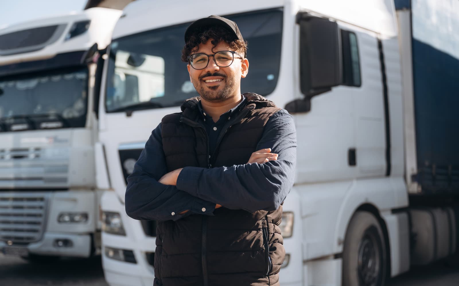 A heavy-vehicle driver standing in front of trucks at a depot, representing the multilingual fleet-savings calculator built for a manufacturer of aerodynamics products.